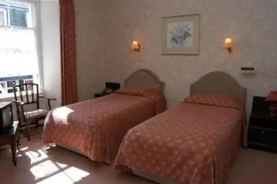 a hotel room with two beds and a table at The Imperial Hotel in Castle Douglas