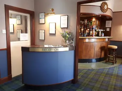 a bar in a pub with a reception counter at The Imperial Hotel in Castle Douglas