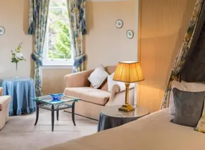 a living room with a couch and a table at Lochgreen House Hotel & Spa in Loans