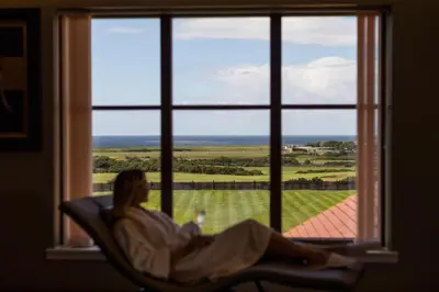 a woman laying in a chair looking out a window at Lochgreen House Hotel & Spa in Loans