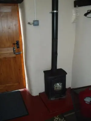 a stove in a room next to a door at Fisher-gill Camping Barn in Thirlmere