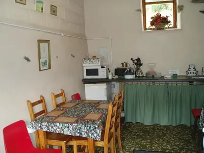 a room with a table and a kitchen with a microwave at Fisher-gill Camping Barn in Thirlmere
