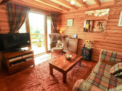 a living room with a television and a couch and a table at Thistle Dubh 