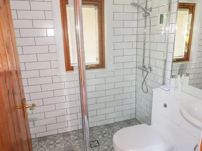 a bathroom with a shower with a toilet and a sink at Thistle Dubh 