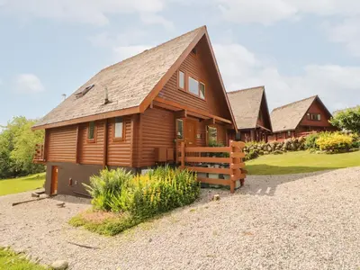 a large wooden house with a gambrel roof at Thistle Dubh 