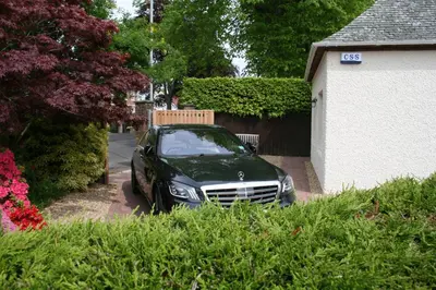 a car parked in a driveway next to a house at Cottage in Ayr