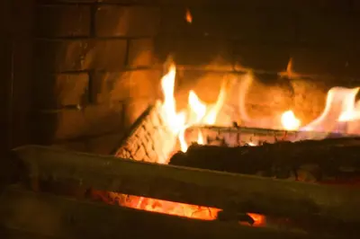 a large brick fireplace with flames in it at Clonyard House Hotel in Dalbeattie