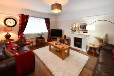 a living room with a couch and a fireplace at Ladyland Cottage in Maybole in Maybole