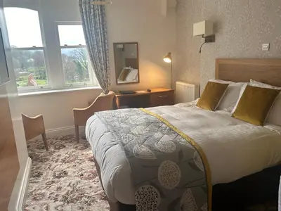 a hotel room with a bed and a desk and window at Burleigh Mead in Keswick