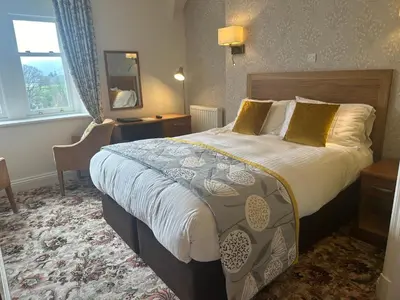 a hotel room with a large bed and a window at Burleigh Mead in Keswick