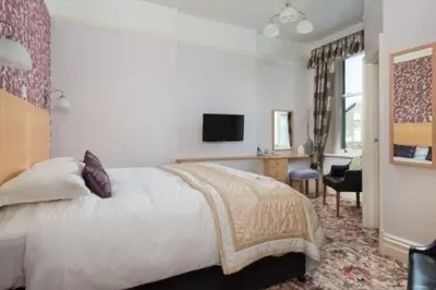 a bedroom with a bed and a desk and a television at Burleigh Mead in Keswick