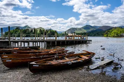 a group of boats sitting on the shore of a lake at Acorn Apartment 2 (upper) in Keswick