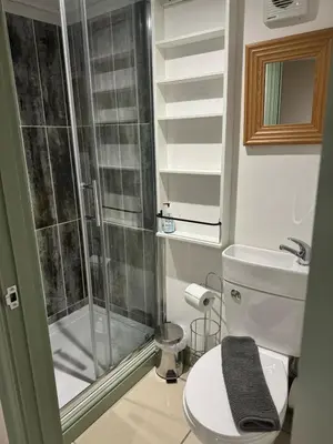 a small bathroom with a shower and a toilet at Doddick Bothy in Threlkeld