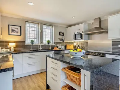 a large kitchen with white cabinets and a counter top at 4 Bed in Crosby-on-Eden 94398 in Crosby