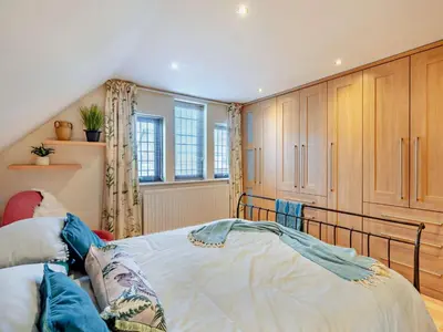 a bedroom with a bed and wooden cabinets at 4 Bed in Crosby-on-Eden 94398 in Crosby