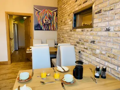 a dining room with a table and a brick wall at Lakeview Guest House in Stranraer