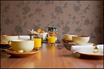 a wooden table with bowls and cups of orange juice at Lakeview Guest House in Stranraer