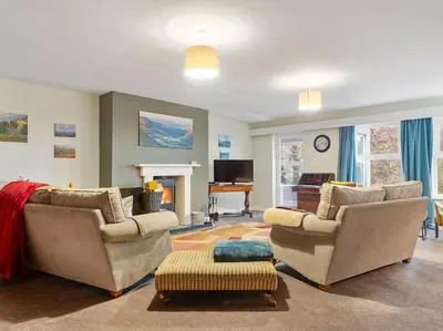 a living room with two couches and a piano at Miterdale A Wonderful Home in the Idyllic Duddon Valley in Broughton in Furness