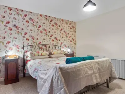 a bedroom with a bed with floral wallpaper at Miterdale A Wonderful Home in the Idyllic Duddon Valley in Broughton in Furness