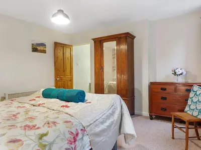 a bedroom with a bed and a wooden dresser at Miterdale A Wonderful Home in the Idyllic Duddon Valley in Broughton in Furness