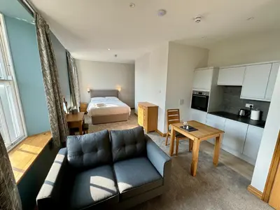 a living room with a couch and a bed in a room at Grindal Studio Apartments - Newly Opened Luxury Accommodation in St Bees