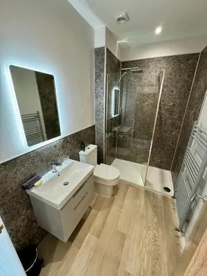 a bathroom with a sink and a shower and a toilet at Grindal Studio Apartments - Newly Opened Luxury Accommodation in St Bees