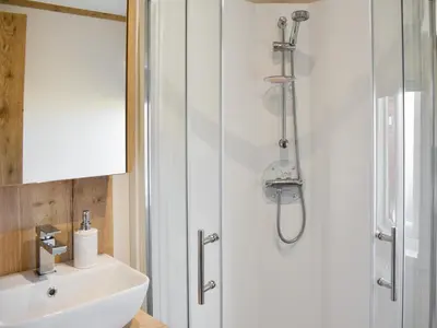 a bathroom with a shower and a sink at Beaumont Lodge in Plumbland
