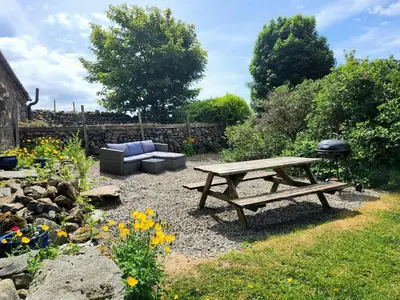 a picnic table and a couch in a garden at 3 Bed in Eskdale 94529 in Eskdale