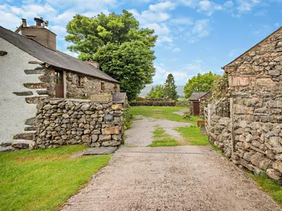 a dirt road between two stone buildings at 3 Bed in Eskdale 94529 in Eskdale