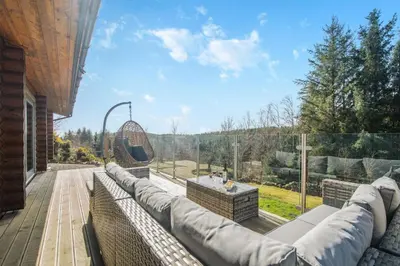 a patio with a couch and a table on a balcony at 3 Bed in Colvend oc-t28900 in Kippford