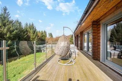 a porch with a swinging chair on a deck at 3 Bed in Colvend oc-t28900 in Kippford
