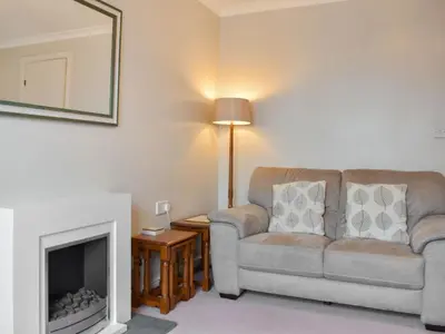 a living room with a couch and a fireplace at Grisedale View - Hewetson Court in Keswick