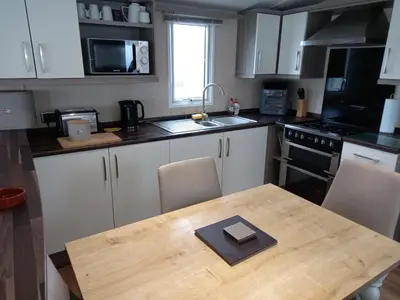 a kitchen with a wooden table with a book on it at Green Dream in Cockermouth