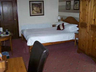 a hotel room with a bed and a table and a chair at The Ennerdale Country House Hotel ‘A Bespoke Hotel’ in Cleator