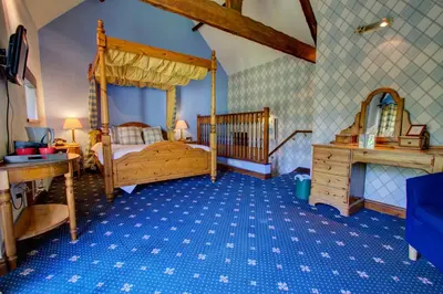 a bedroom with a wooden bed and a wooden dresser at The Ennerdale Country House Hotel ‘A Bespoke Hotel’ in Cleator