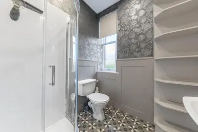 a bathroom with a toilet and a glass shower at Ashbrooke Apartment Keswick at The Lairbeck in Keswick