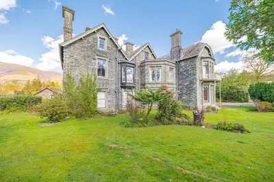 an old stone house on a green lawn at Ashbrooke Apartment Keswick at The Lairbeck in Keswick