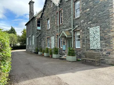 a brick building with a bench in front of it at Ashbrooke Apartment Keswick at The Lairbeck in Keswick