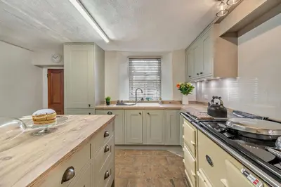 a large kitchen with white cabinets and a counter top at 4 Bed in Kinniside oc-c28854 in Frizington