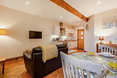 a living room with a dining room table and a kitchen at 1 Bed in Irthington oc-t28309 in Irthington