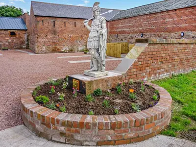 a statue of a woman standing in a garden at 2 Bed in Irthington oc-v28308 in Irthington