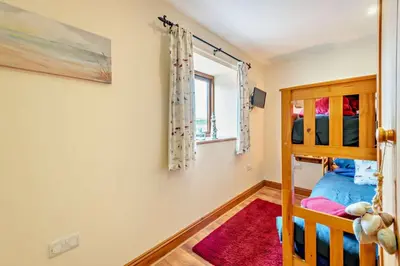 a bedroom with a bunk bed and a window at 2 Bed in Irthington oc-v28308 in Irthington