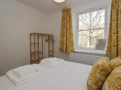 a bedroom with a bed with white sheets and a window at Dalegarth Hall Farm Cottage 1 in Holmrook