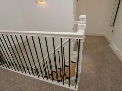 a white stair railing in a room with carpet at Dalegarth Hall Farm Cottage 1 in Holmrook