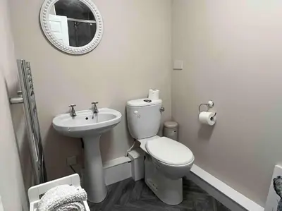 a white bathroom with a toilet and a sink at The Print Room, 1 Bedroom Ground Floor Apartment in Carlisle