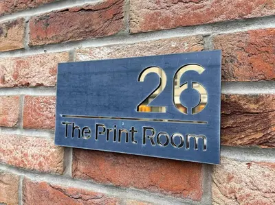 a sign on a brick wall with the room at The Print Room, 1 Bedroom Ground Floor Apartment in Carlisle