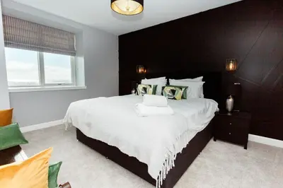 a bedroom with a large bed with a black headboard at Disdow House in Gatehouse of Fleet