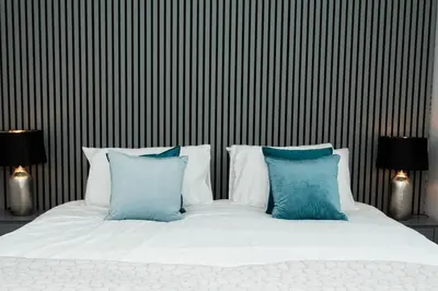 a white bed with blue pillows in a bedroom at Disdow House in Gatehouse of Fleet