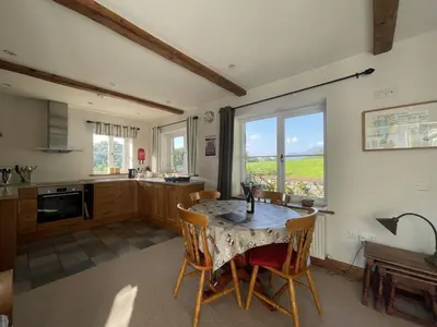 a kitchen with a table and chairs and a window at Deer Close Cottage in Keswick
