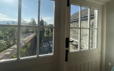an open door with a view of a house at Deer Close Cottage in Keswick